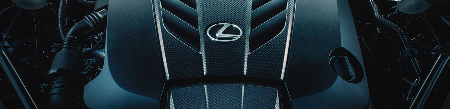 Close up of an engine featuring the Lexus emblem.