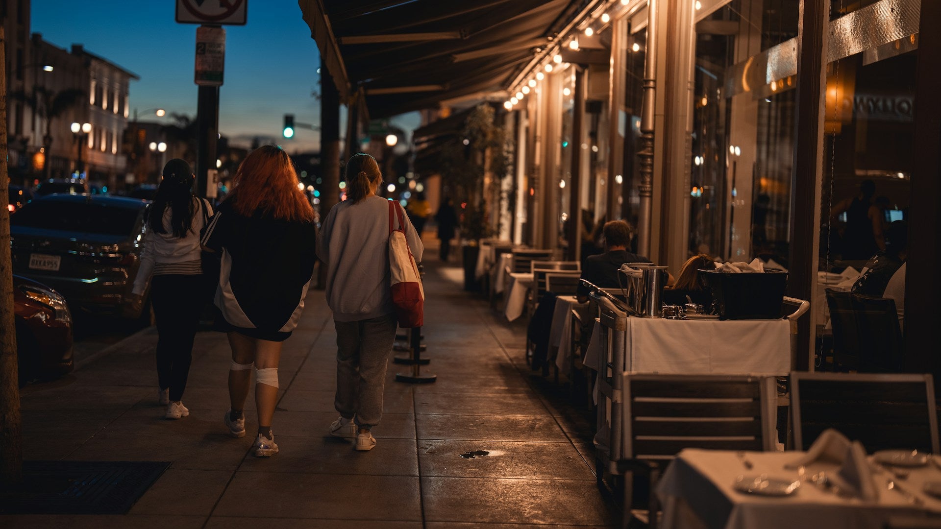 A couple of people walking down a sidewalk